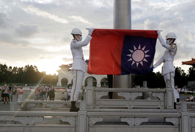 <p>Taiwanese soldiers hold their national flag in Taipei</p>