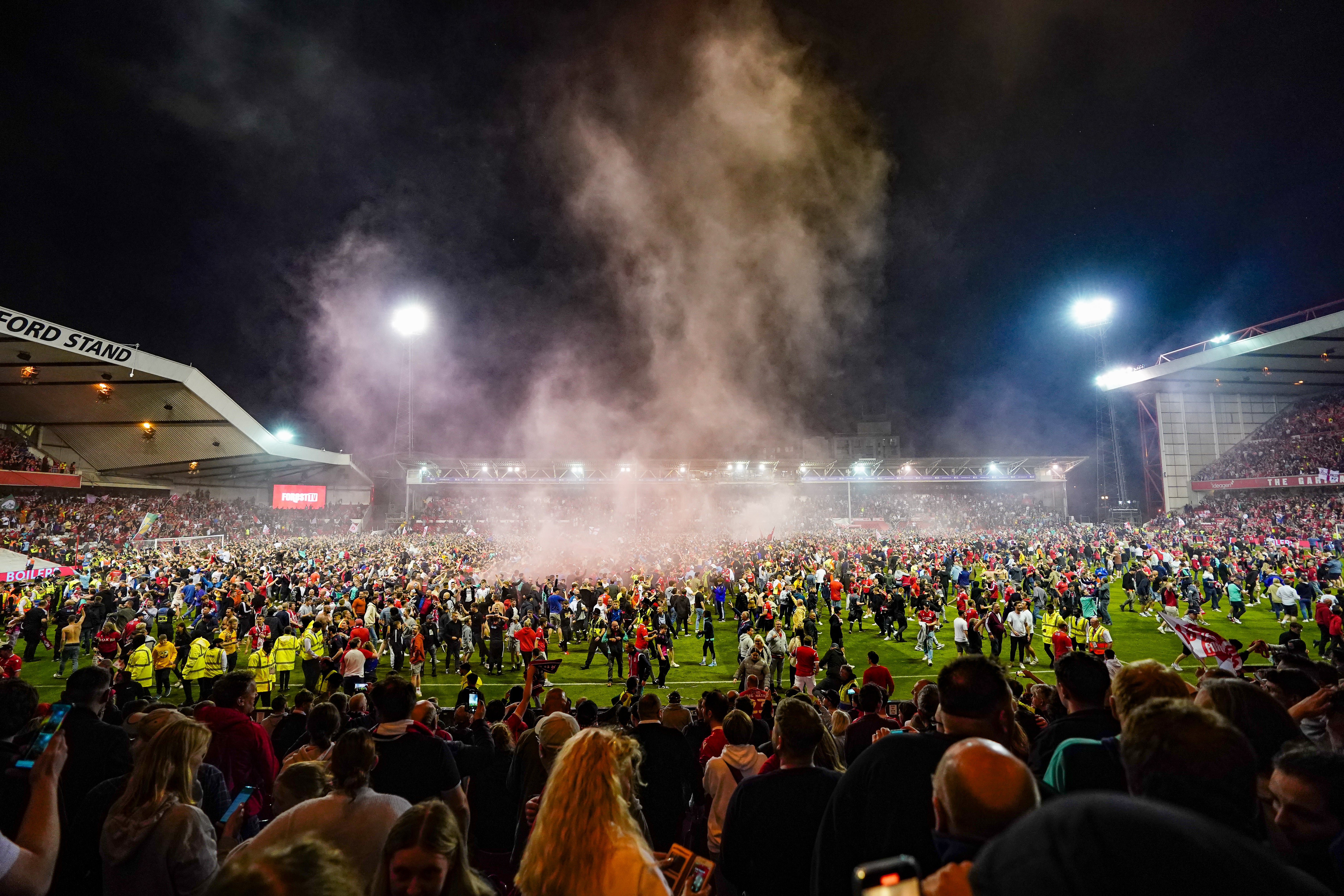 Nottingham Forest fans celebrate on the pitch after they reach the play-off final (Zac Goodwin/PA)
