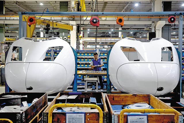 <p>A Voith Turbo employee works on the Shanghai assembly line on July 21, 2022 </p>