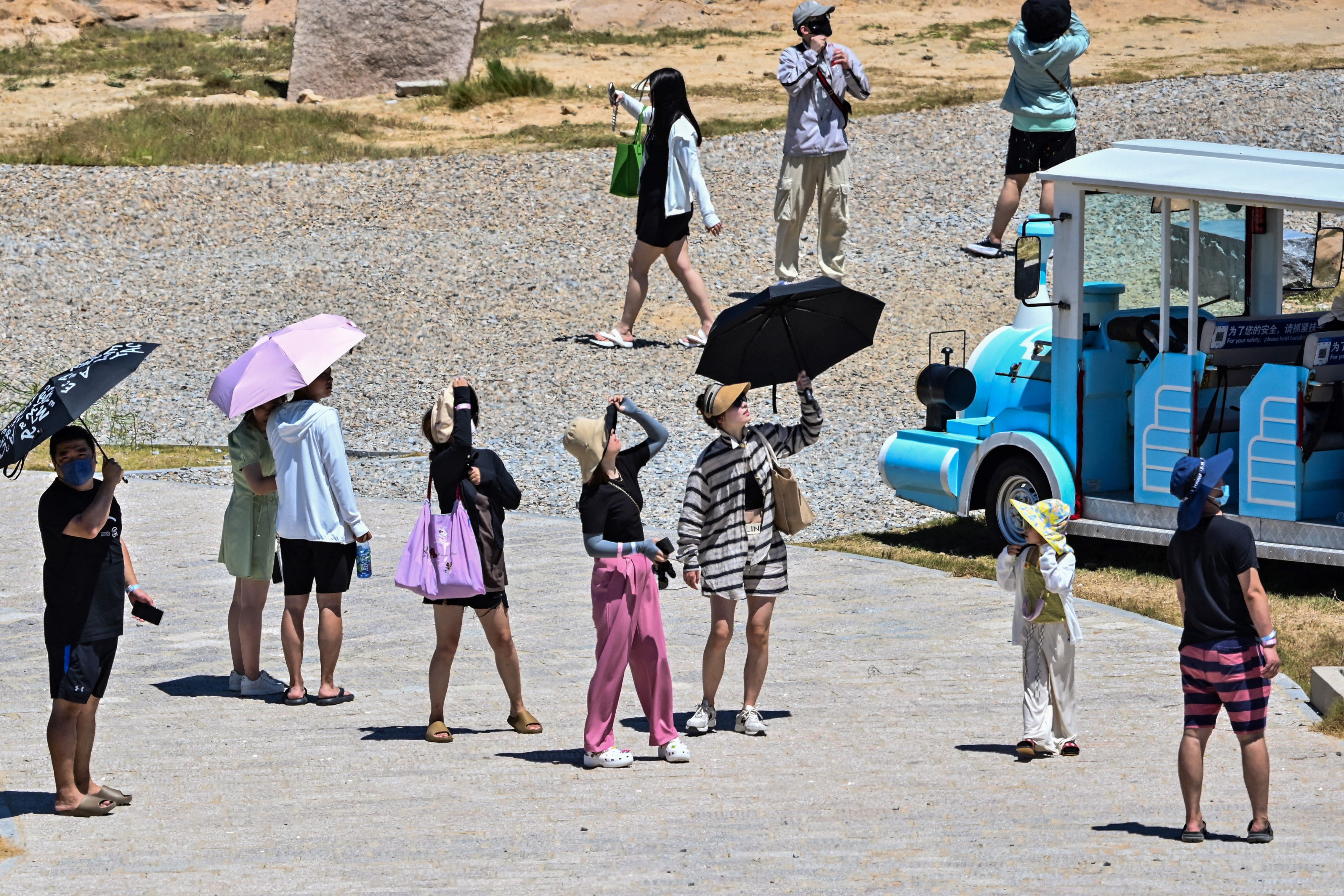 Tourist look up as a Chinese military jet flies over Pingtan island, one of mainland China’s closest point from Taiwan, in Fujian province on 5 August 2022