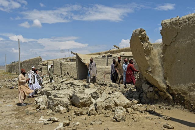 <p>Flood-affected residents clear debris after the dam in Pishin district of Balochistan broke due to heavy rains</p>