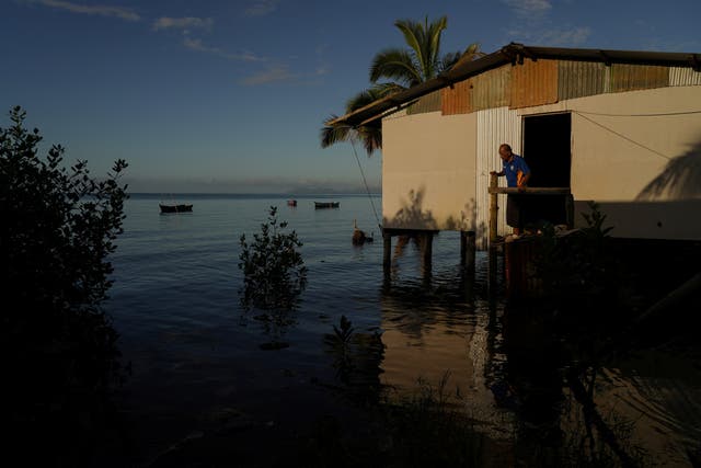 <p>Local resident Rapuma Tuqio, 67, looks out at seawater flooding around his home at high tide in Veivatuloa village, Fiji</p>