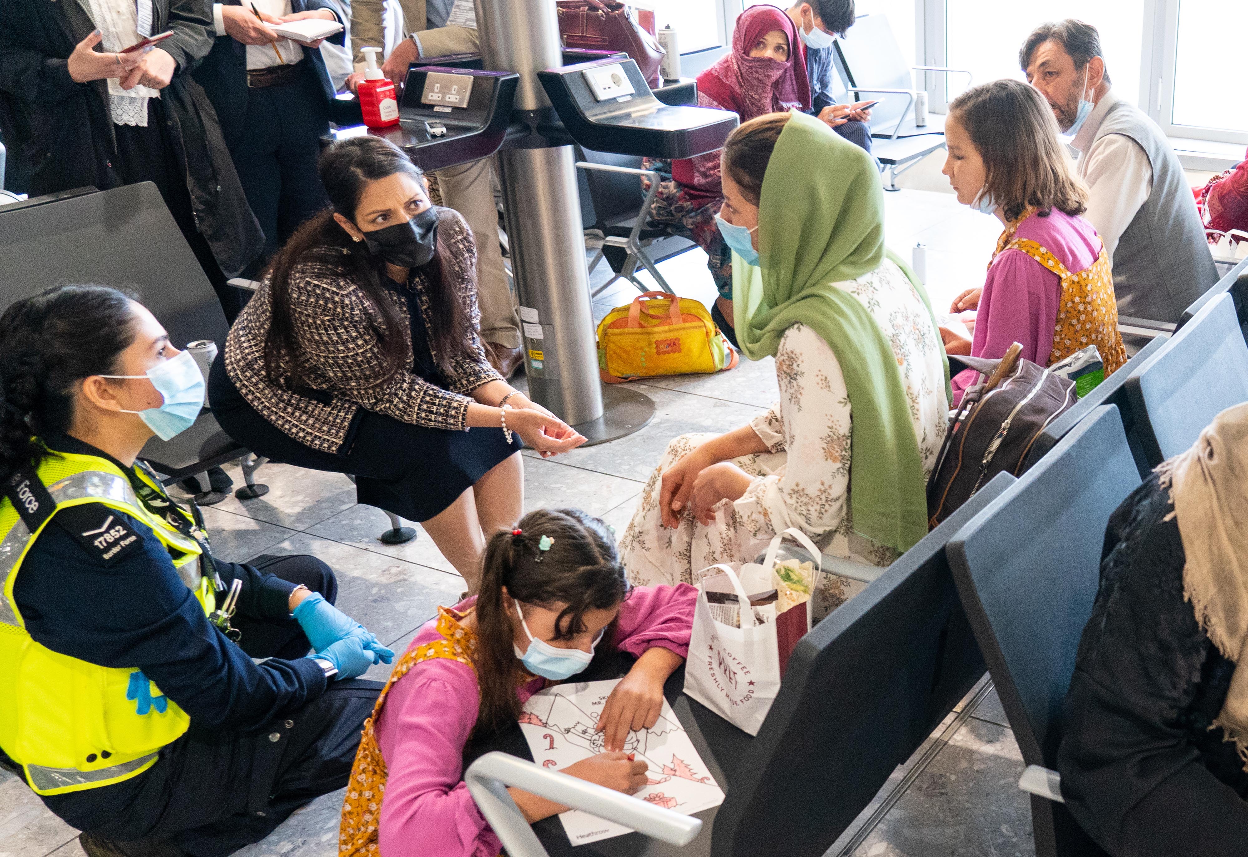 Patel speaks with refugees at Heathrow