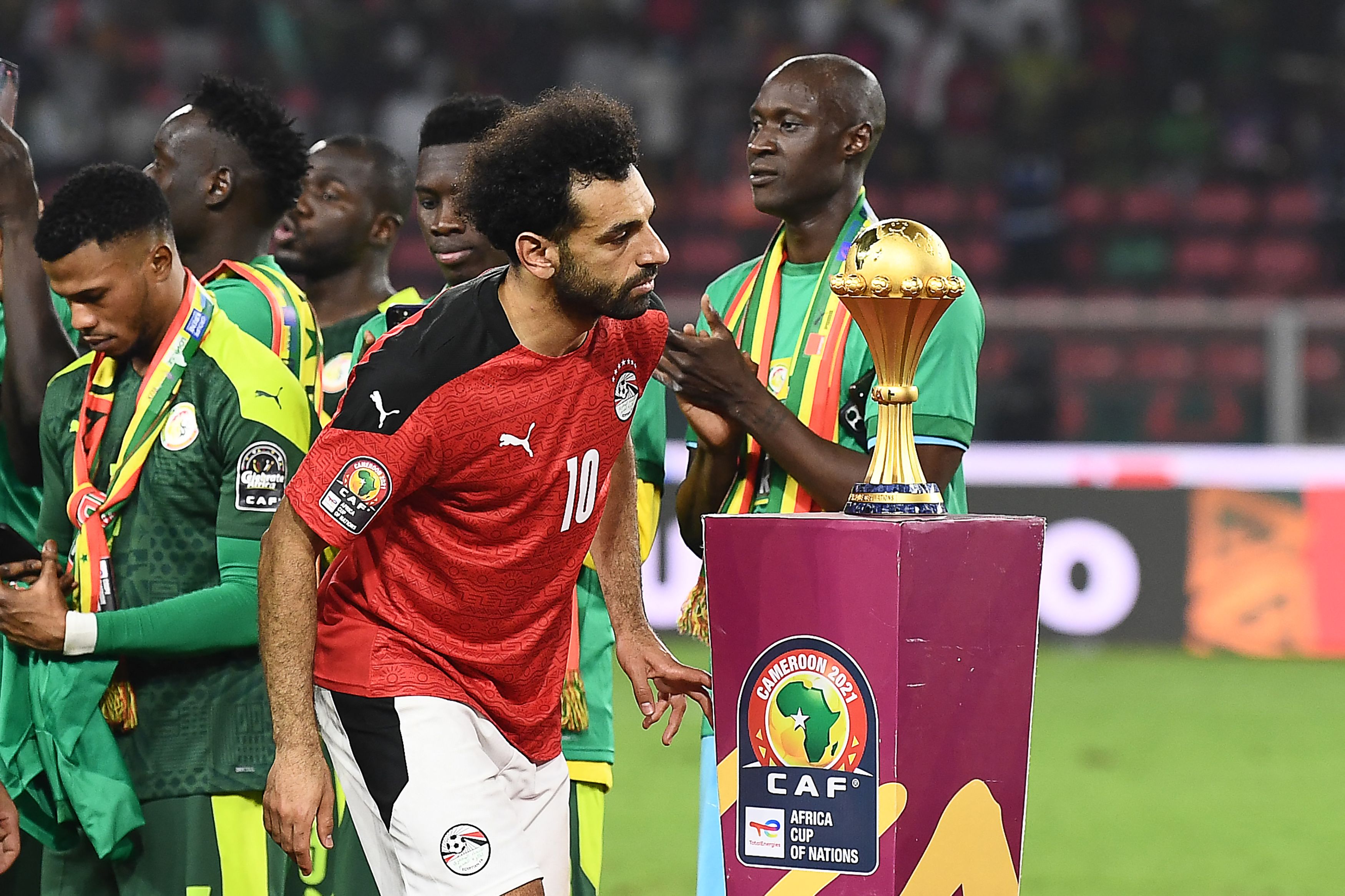 Salah walks past the trophy after Senegal’s triumph on penalties