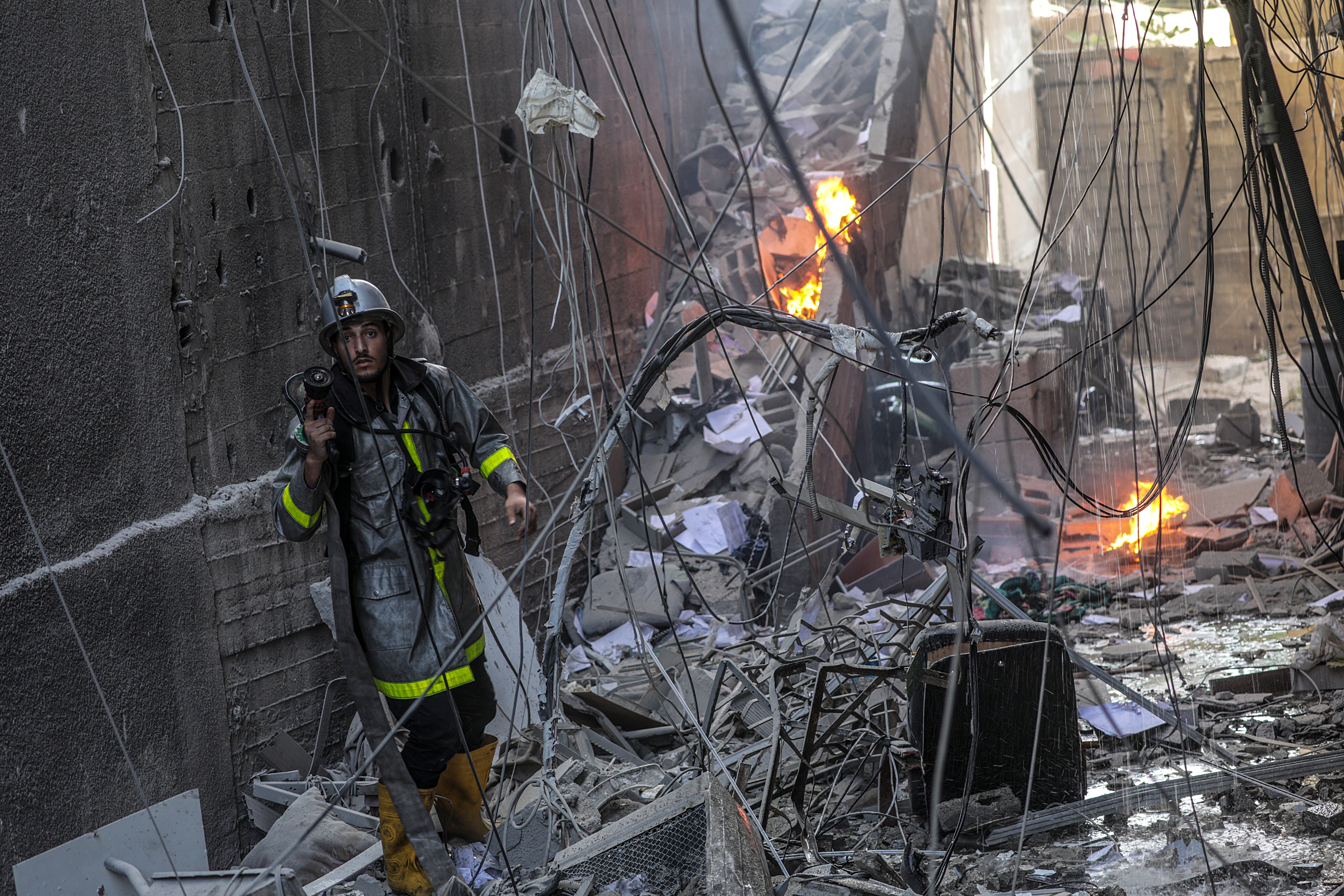 A Palestinian firefighter works at the site of a destroyed building