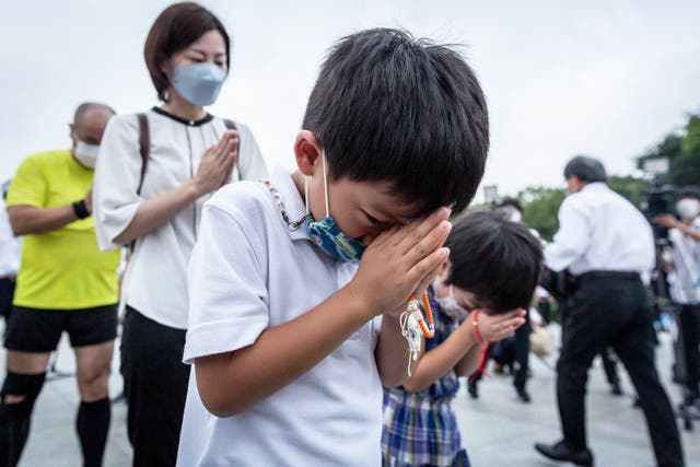 <p>A child prays in remembrance during the 77th anniversary of the Hiroshima atomic bombing on 6 August 2022 in Hiroshima, Japan</p>