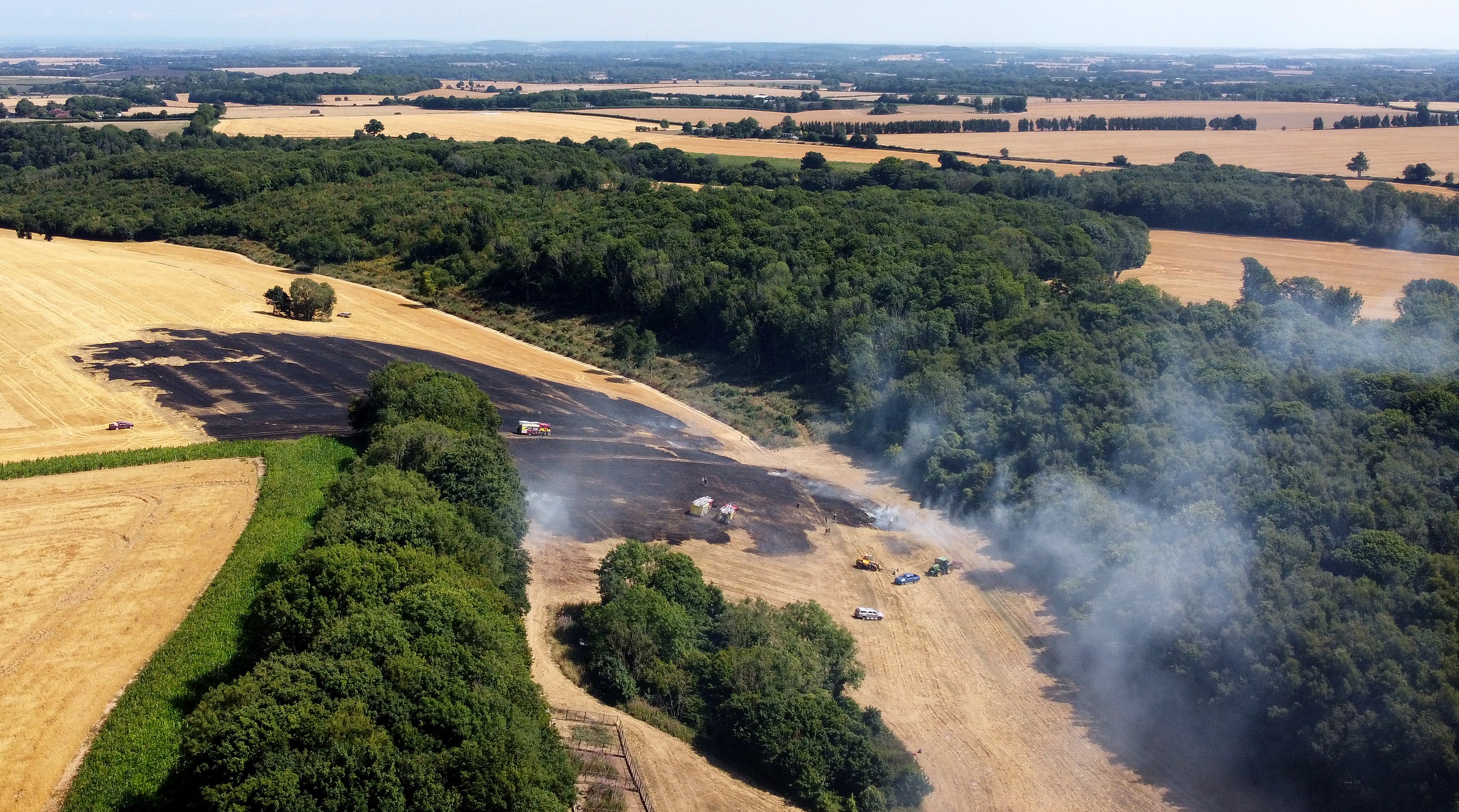 Firefighters bring a field fire under control near Ashford in Kent (Gareth Fuller/PA)