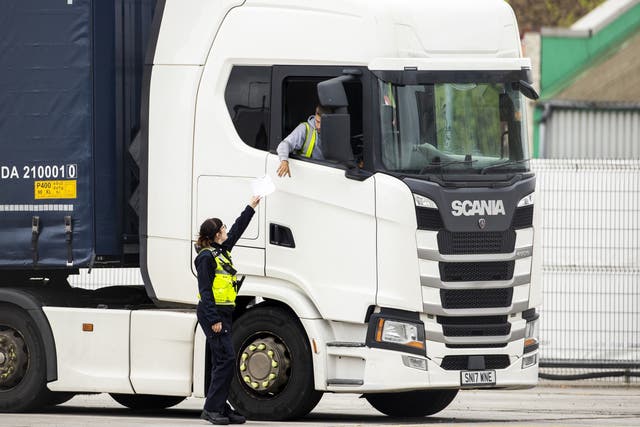 A Border Force Officer returns papers to a haulage driver after checks at Belfast Port (PA)