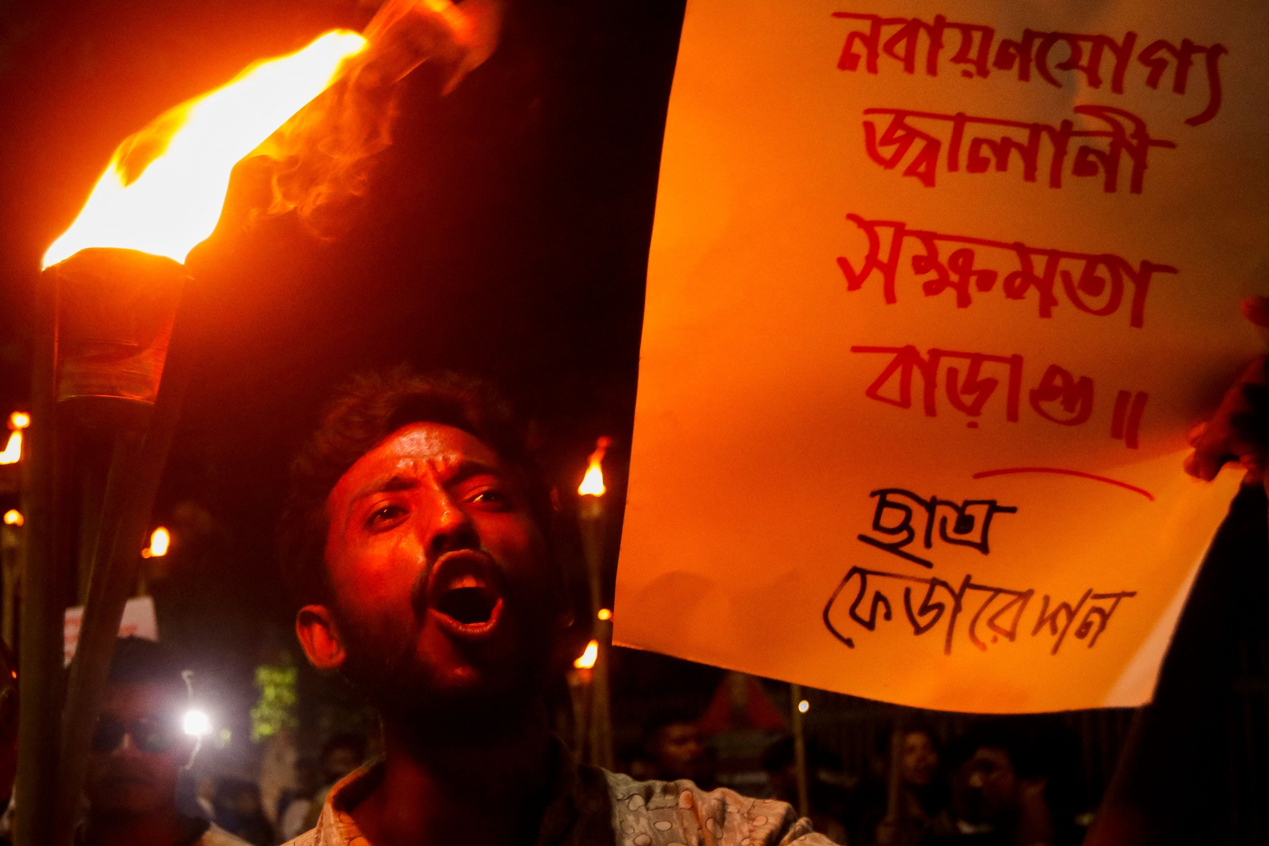 An activist displays a banner and shout slogans during a torch rally to protest against rising fuel prices in Dhaka