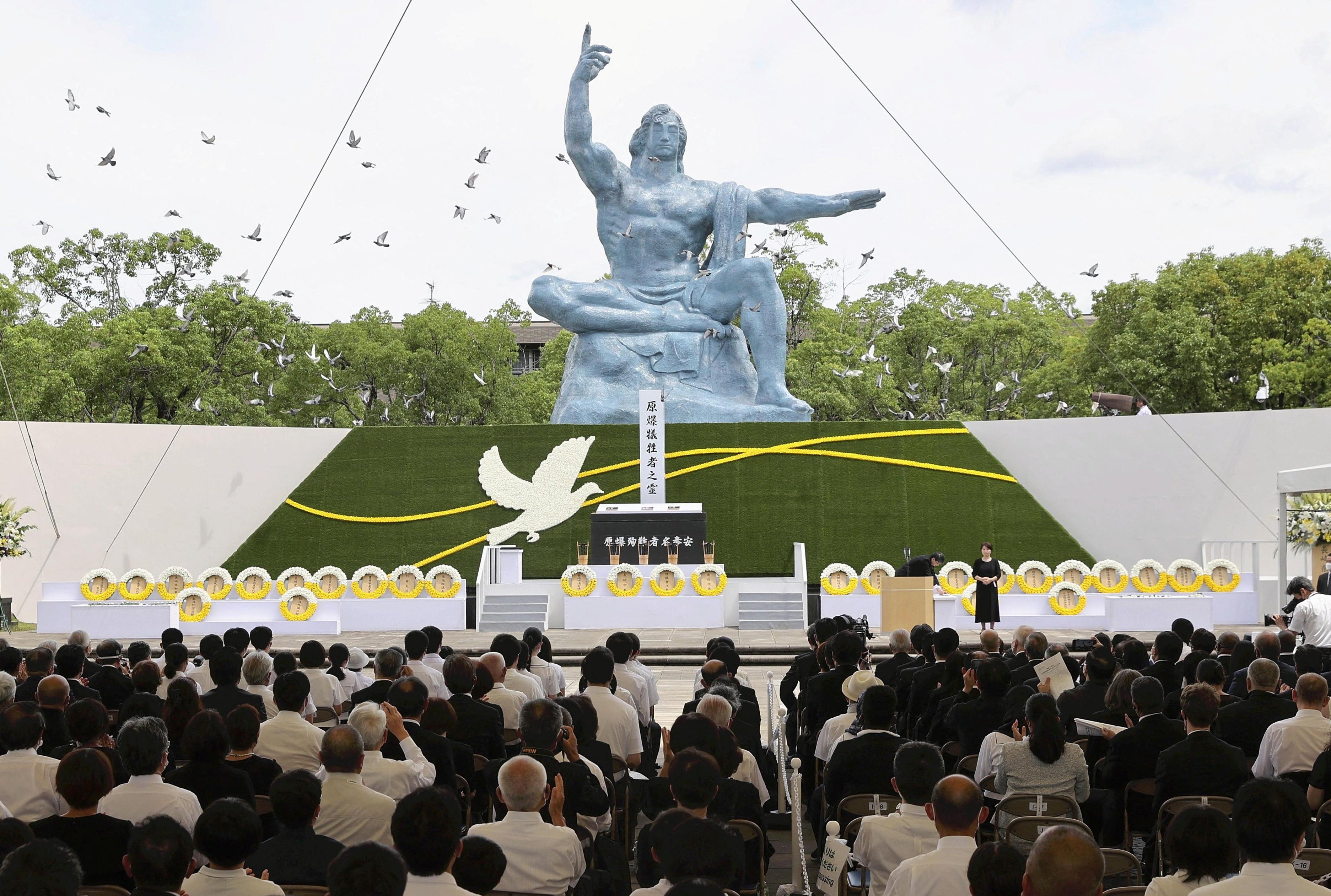Doves fly over the Peace Statue during a ceremony commemorating the 77th anniversary of the bombing of the city at Nagasaki Peace Park