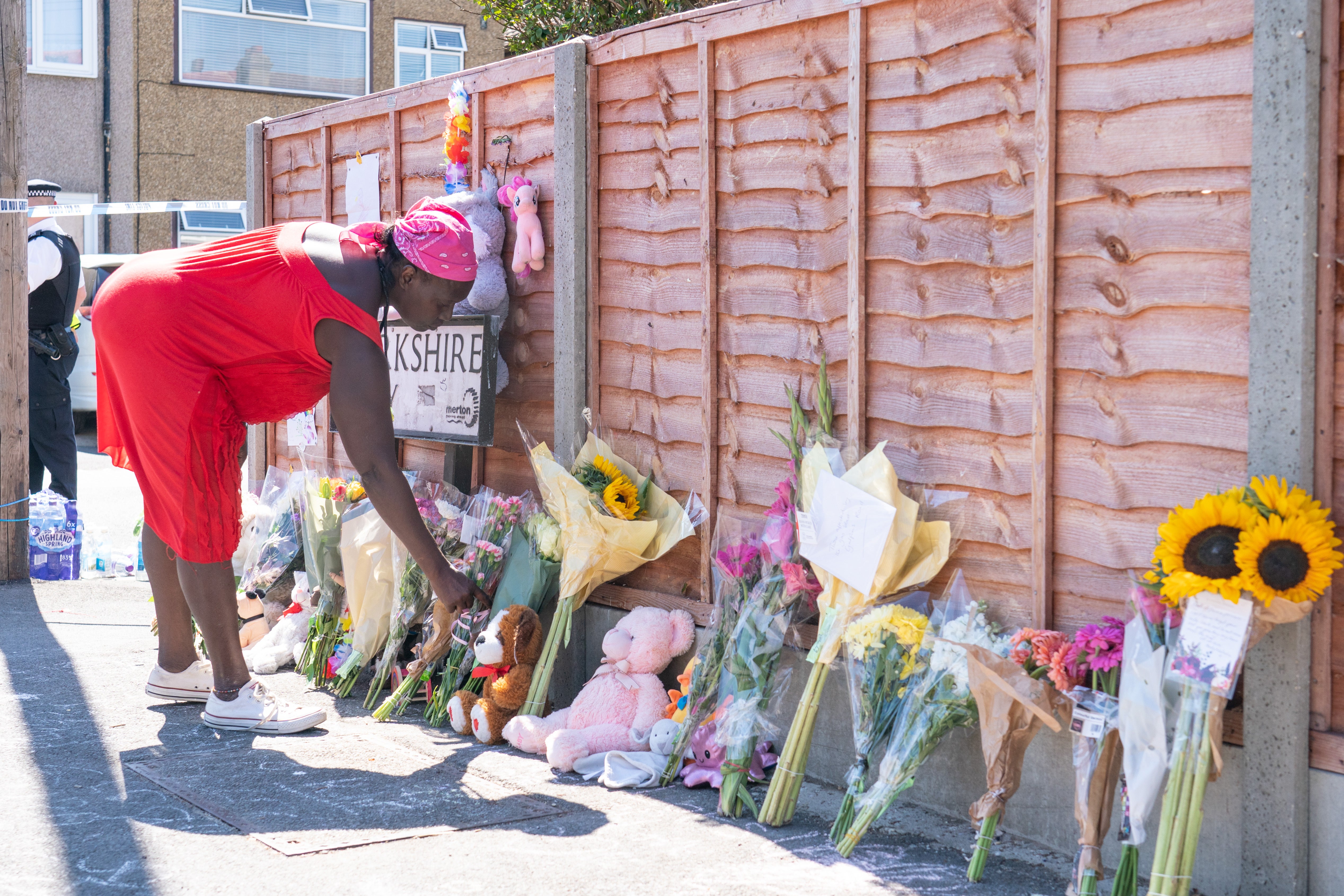 A woman lays flowers near the scene of the explosion (Dominic Lipinski/PA)