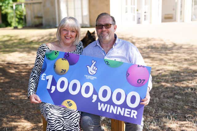 NHS worker Maxine Lloyd and her fiance, Wayne Tilbury, from Kettering, celebrate her winning £1m win on one of the National Lottery’s instant win games (Jacob King/PA)