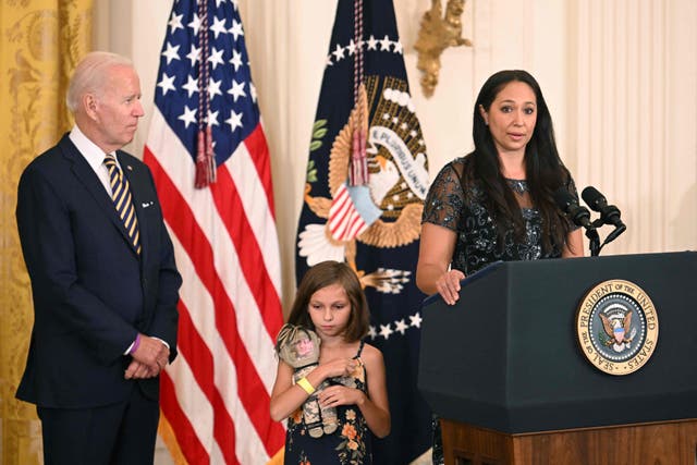 <p>President Joe Biden looks on as Danielle Robinson, wife of Sgt First Class Heath Robinson, speaks during a signing ceremony for the PACT Act of 2022</p>
