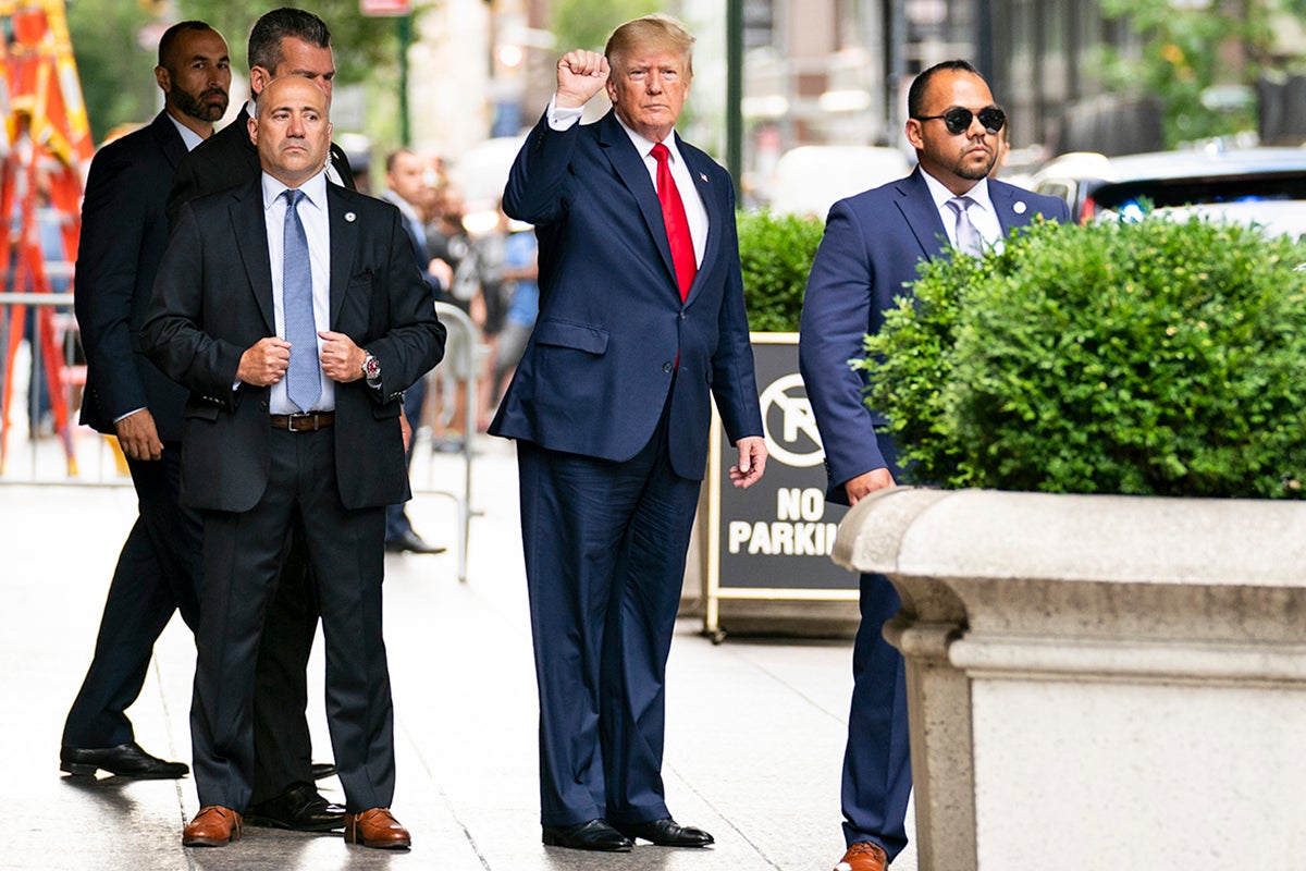 Former President Donald Trump gestures as he departs Trump Tower on his way to deposition