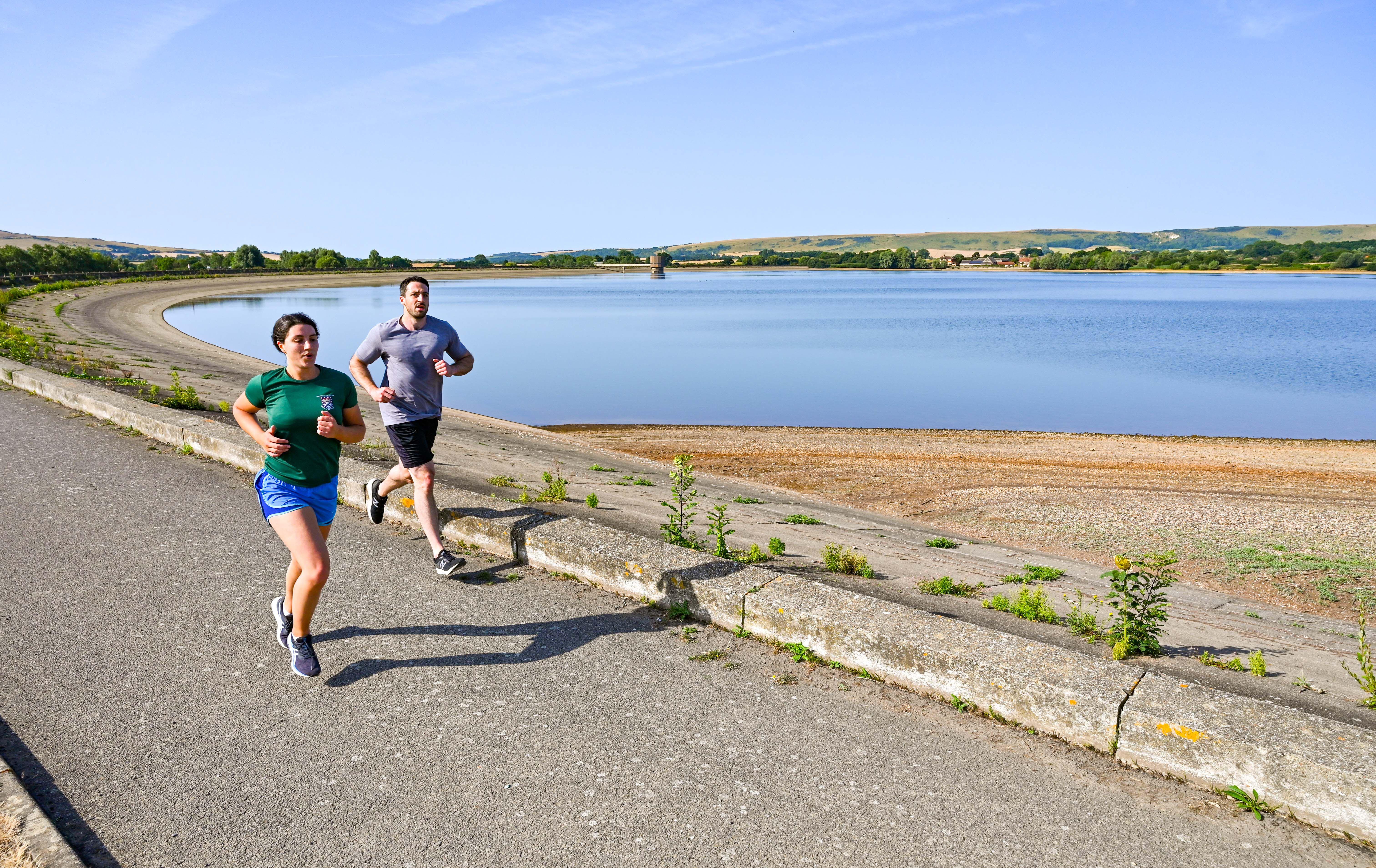 Early morning runners at Arlington Reservoir near Lewes in East Sussex in July (Simon Dack News/Alamy/PA)
