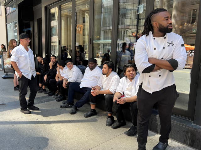<p>Kitchen staff wait outside a restaurant during an electricity outage in Toronto, Canada, on Aug 11 2022</p>