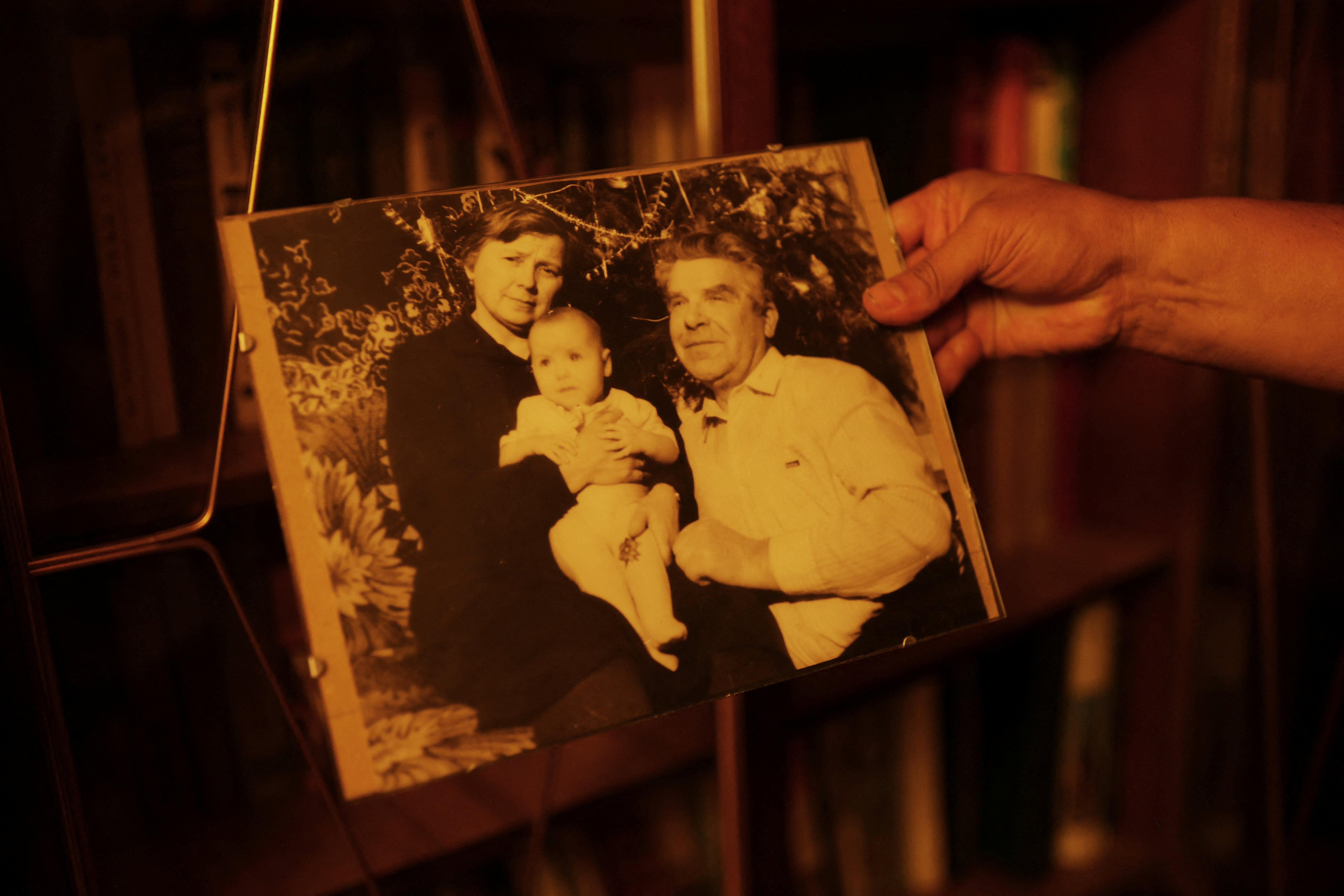 Fedor holds a photo of his wife Natalya as a baby with her parents Maria, and her late father, Vasilii