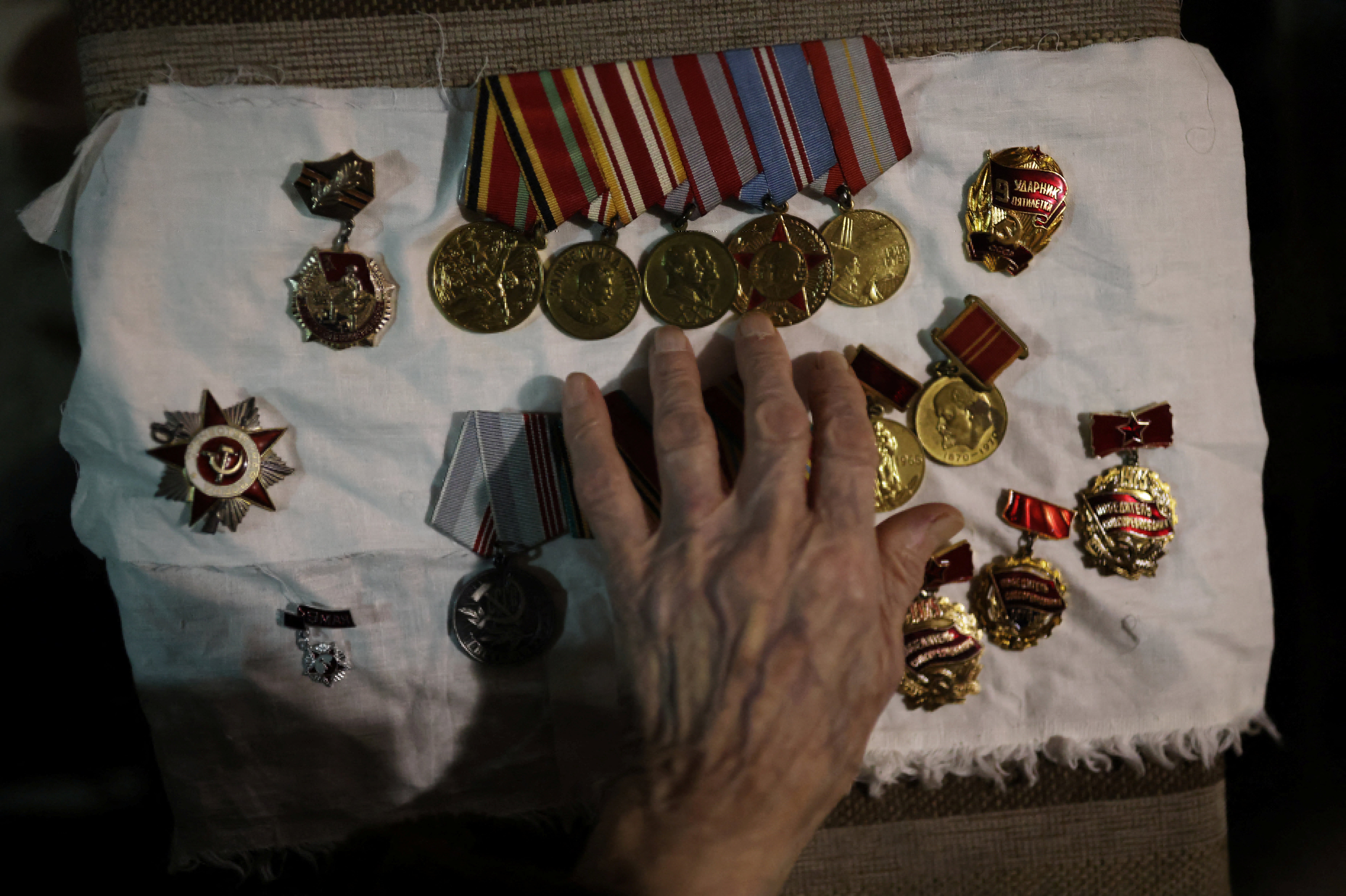 Maria arranges the medals awarded to her late husband, Vasilii Emelianovich