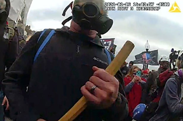 Thomas Robertson wields a wooden stick to block police officers outside the US Capitol on January 6