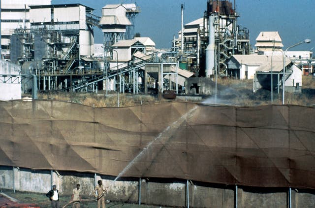 <p>Firemen wet canvas screens to prevent spread of dangerous fumes at the Union Carbide plant in Bhopal, India, on 3 December 1984</p>