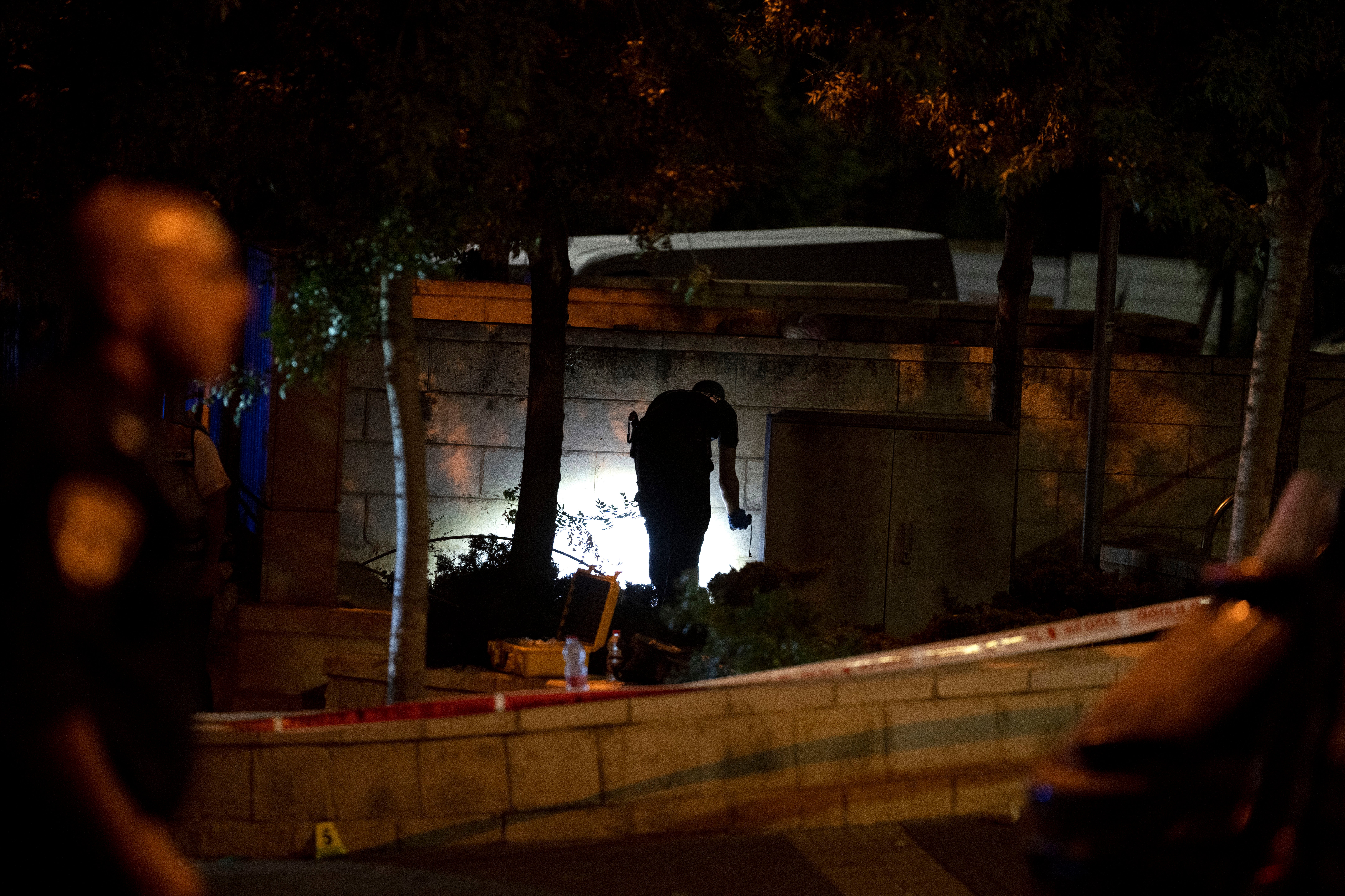<p>An Israeli police crime scene investigator works at the scene of a shooting attack </p>
