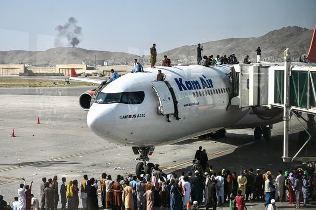 <p>Desperate people climb on top of a plane at Kabul airport on 16 August 16, 2021, after a stunningly swift end to Afghanistan's 20-year war</p>