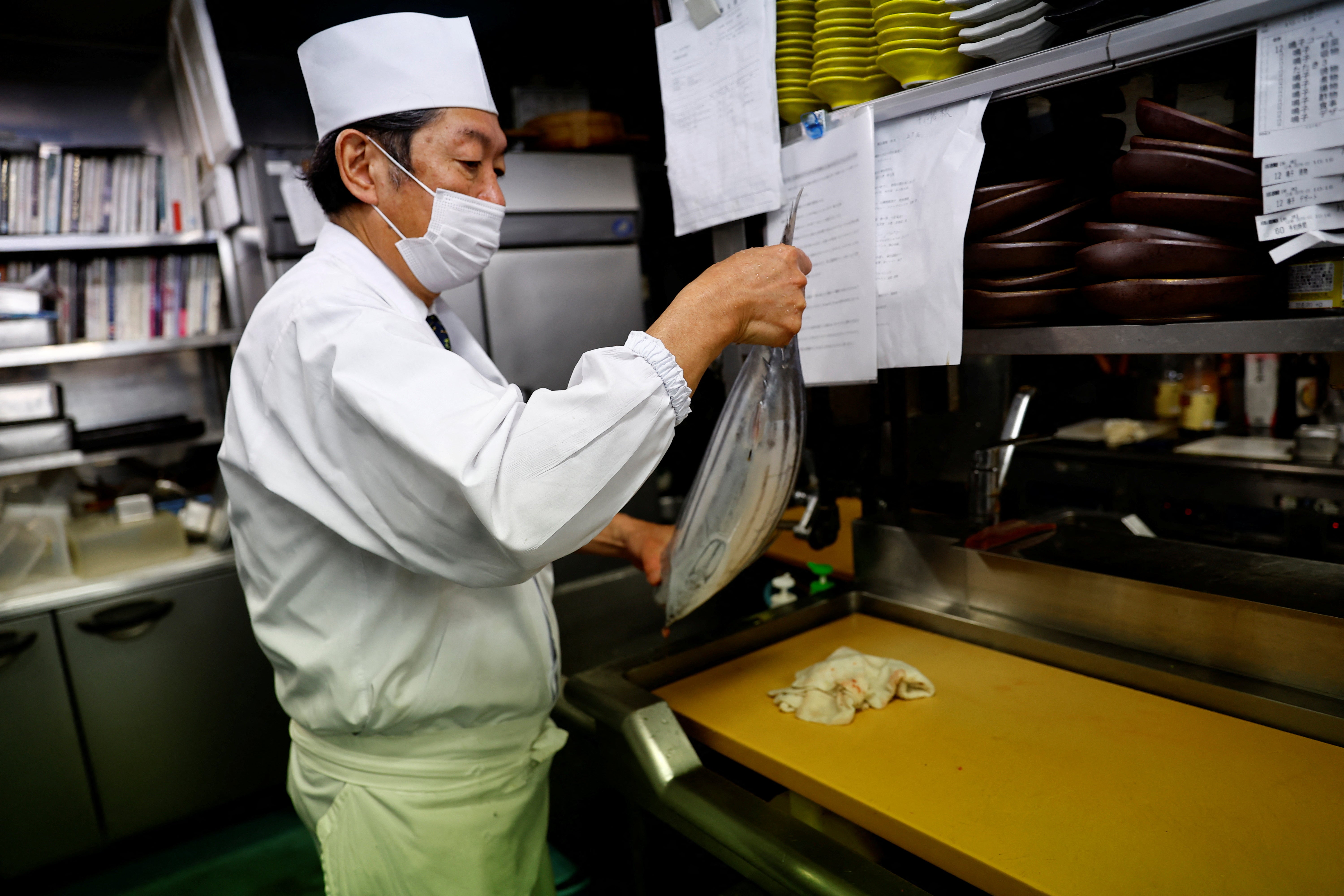 Noriaki Ito, prepares to slice raw katsuo