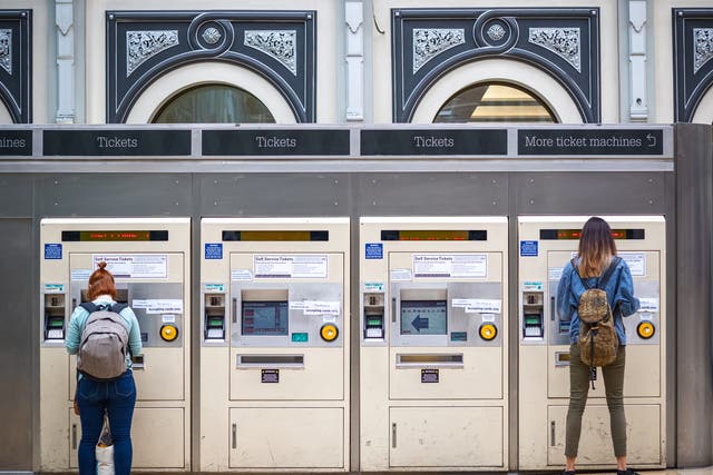 <p>Passengers purchasing train tickets from machines at London Paddington station</p>