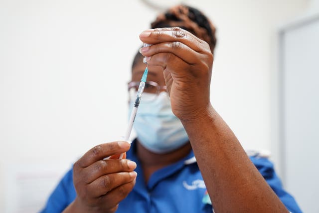 <p>A nurse prepares a dose of a Covid-19 vaccine </p>