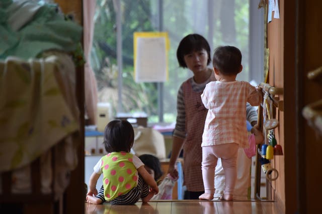 <p>This picture taken on 29 June 2016 shows an employee of an official nursery school taking care of young children in Yokohama</p>