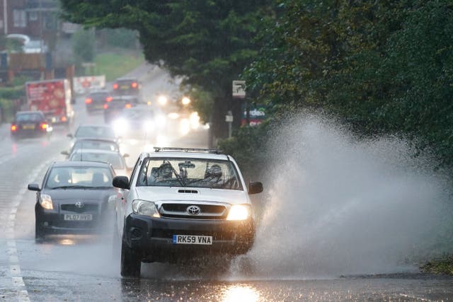 Vehicles travel through standing water during heavy rain in Bromsgrove, West Midlands (Jacob King/PA)