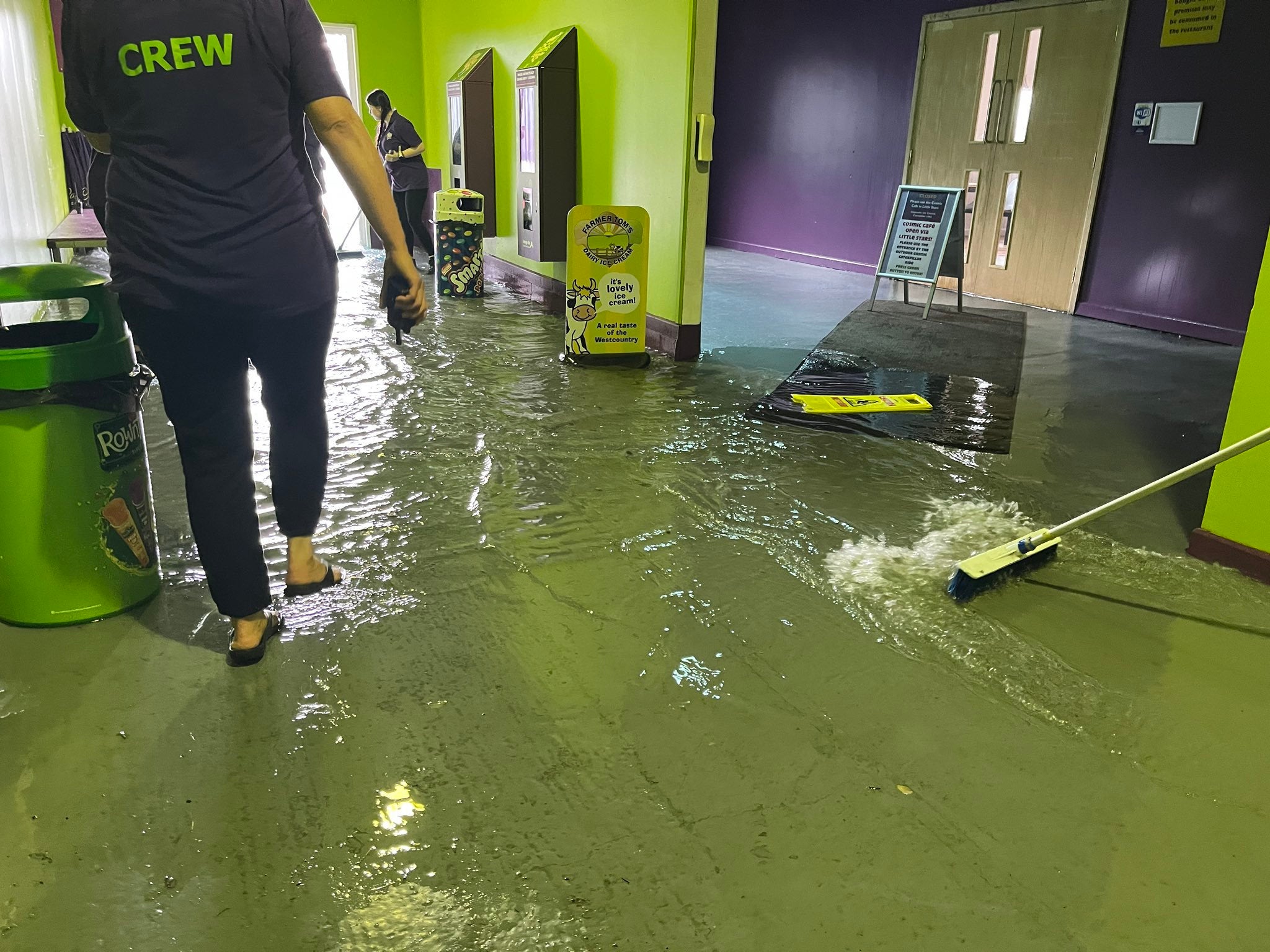 Members of staff at The Milky Way in Devon, clearing out floodwater inside the premises