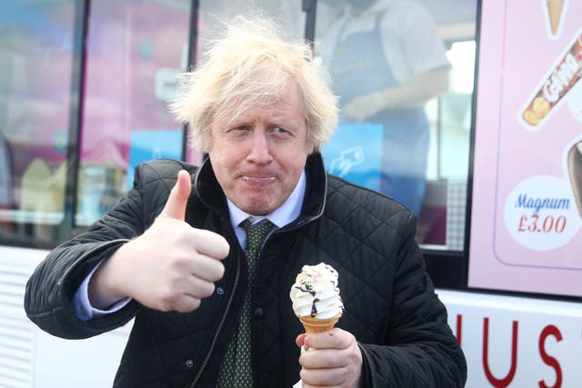 <p>Boris Johnson gives a thumbs up while tucking into an ice cream during a visit to Haven Perran Sands Holiday Park in Perranporth, Cornwall, in April 2021</p>