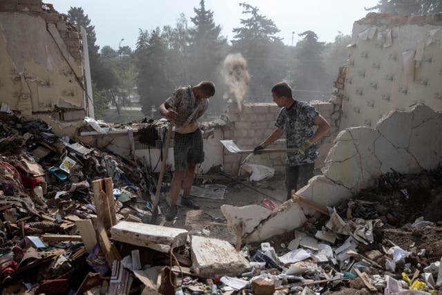 <p>Andre Kovalenko, (left), 34, and Victor, who gave only his first name, work to recover belongings from a badly damaged apartment</p>