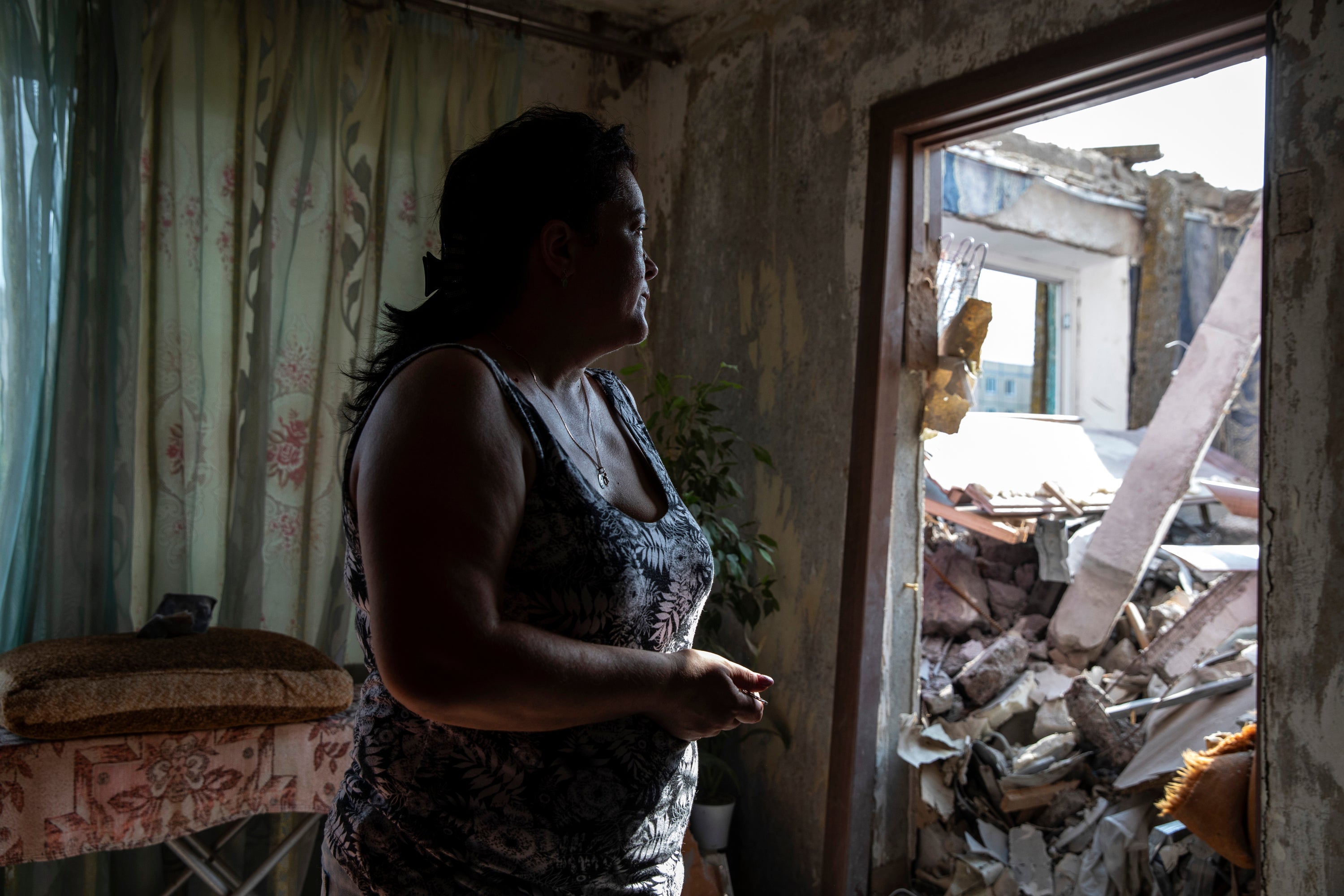 Natalya Khodak, 47, looks at rubble that crashed from above when her apartment building was hit by a Russian strike in Nikopol