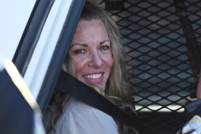 <p>Lori Vallow smiles as she sits in a police car outside court in 2022 </p>