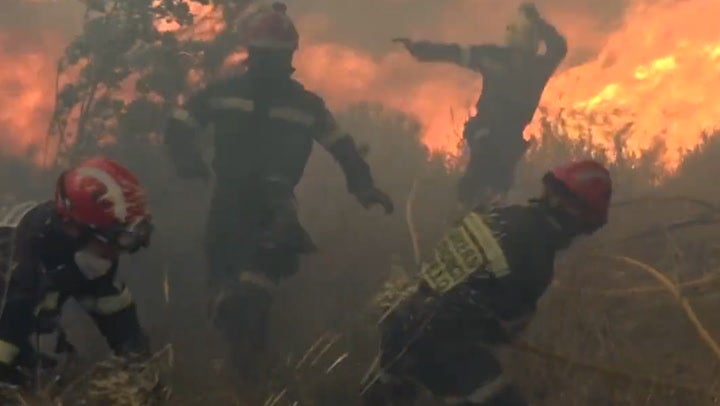Wildfires: Firefighters run from aggressively fast-moving fire in eastern Spain