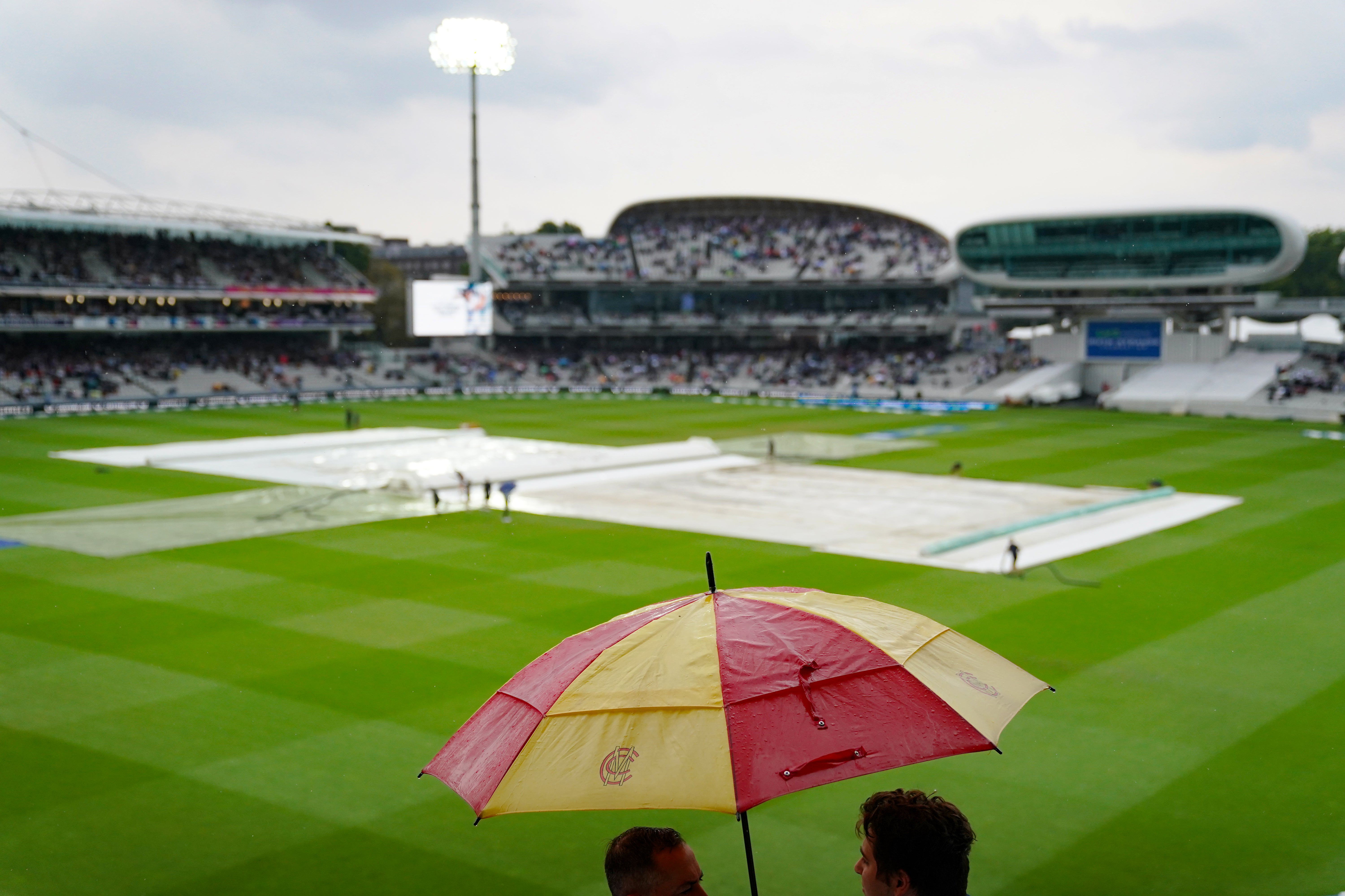 Spectators put up umbrellas as rain stops play during day one at Lord’s (Adam Davy/PA)