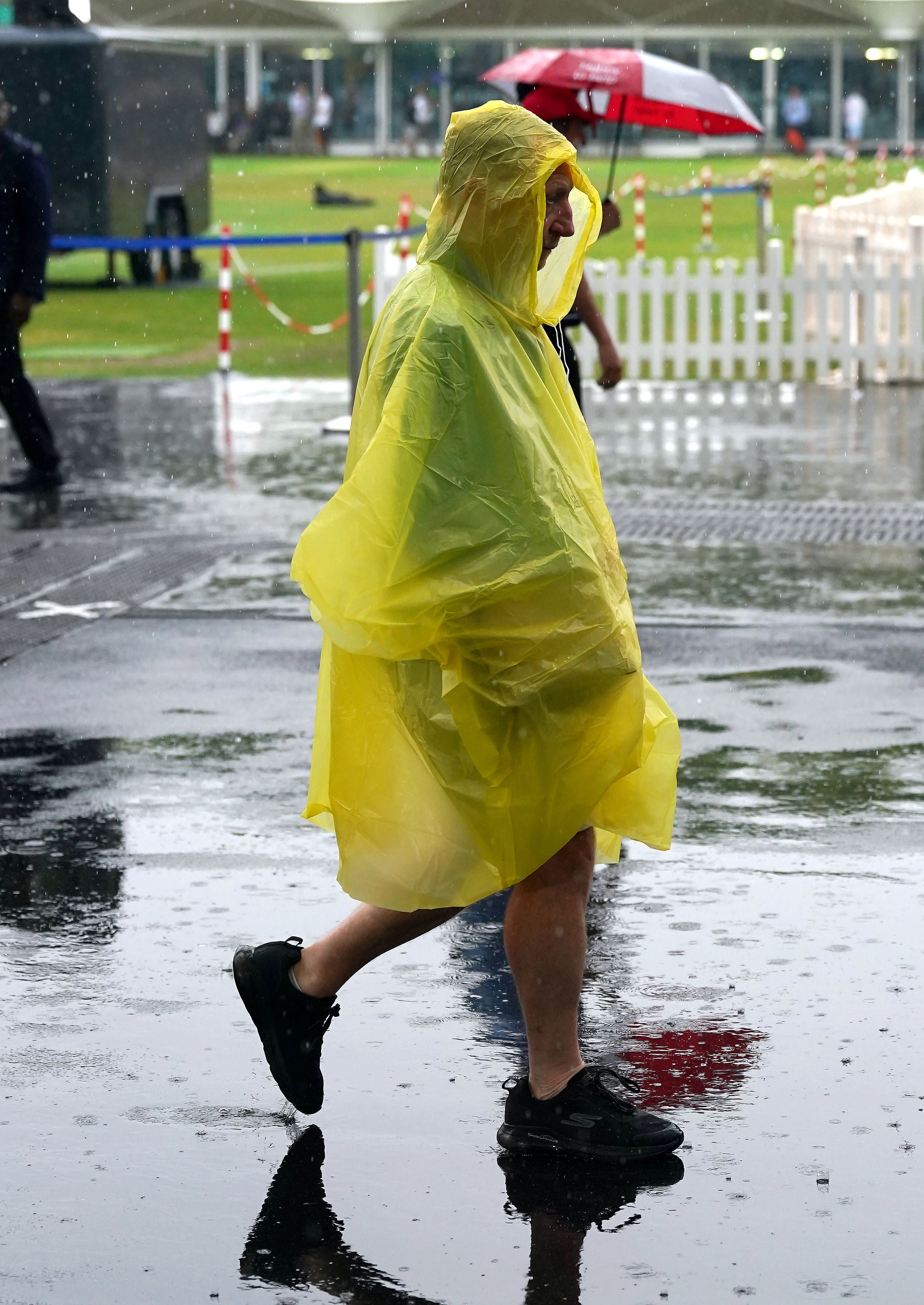 A spectator covers up in the rain