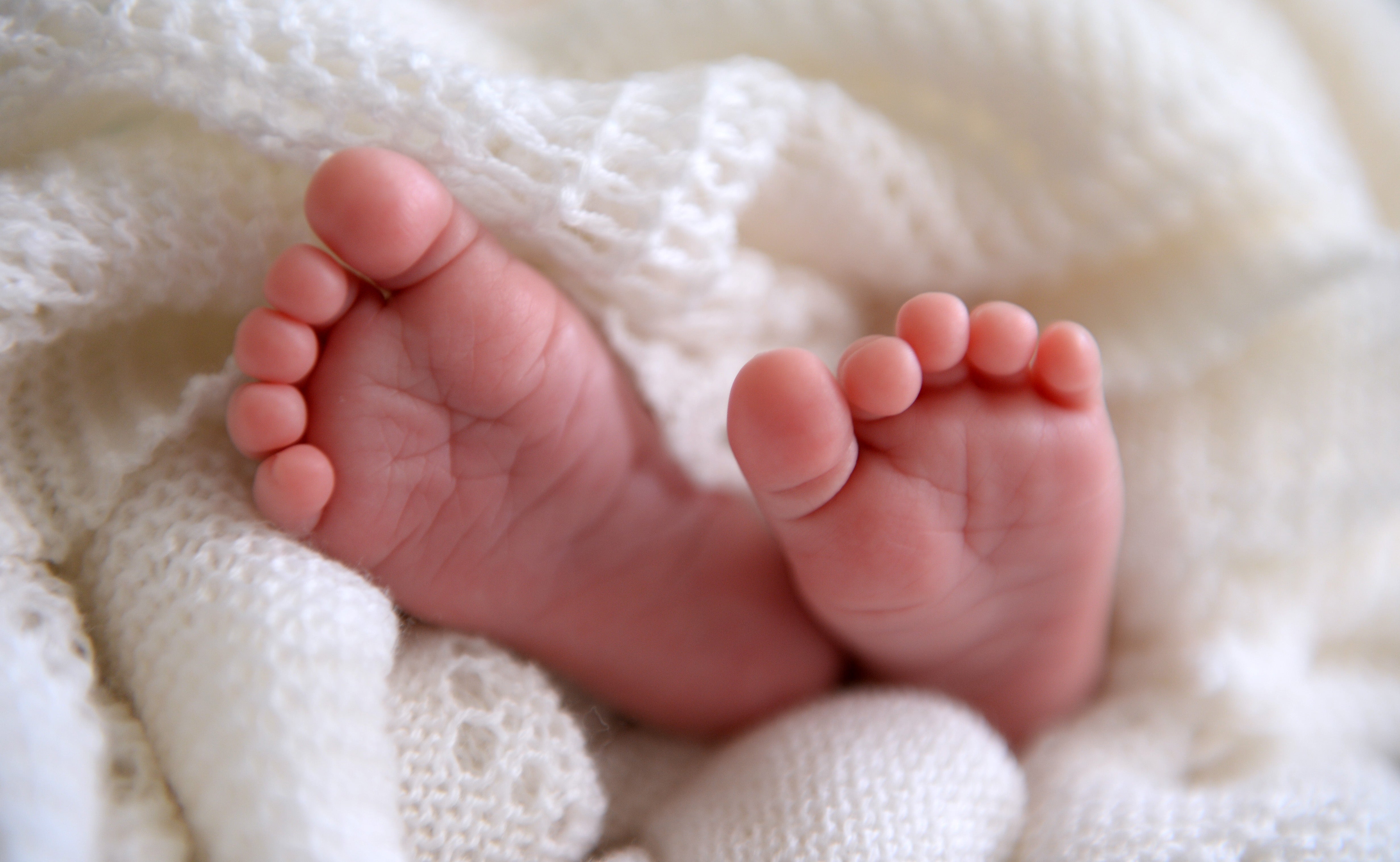 A new-born baby’s feet (Andrew Matthews/PA)
