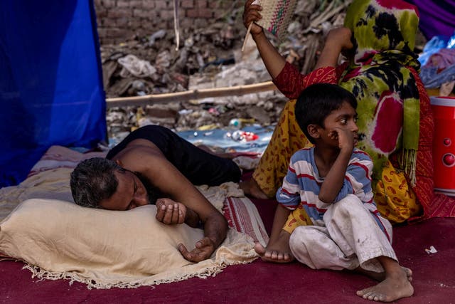 <p>File: A Rohingya refugee family rests in a temporary shelter in Delhi</p>