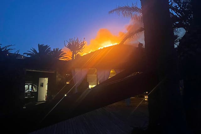 Un incendio forestal arde detrás de la villa del diseñador de moda Giorgio Armani en Pantelleria, una isla frente a la costa de Sicilia.
