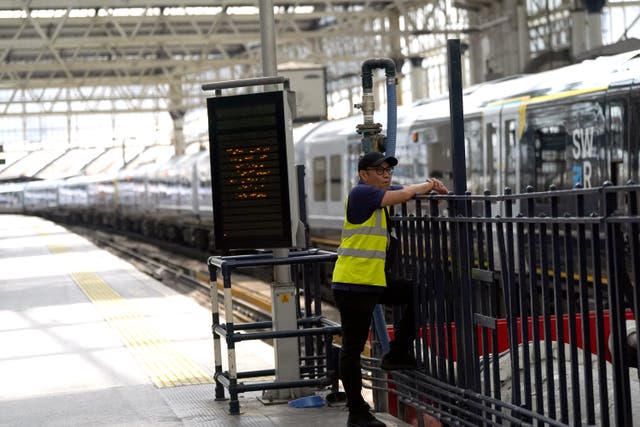 A member of staff on a empty platform platform at Waterloo Station (Victoria Jones/PA)