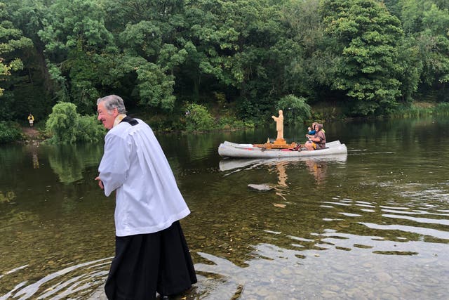 <p>Father Richard Williams of St Mary’s Church in Hay-on-Wye sees the statue of the Virgin Mary off on her 75-mile river pilgrimage</p>