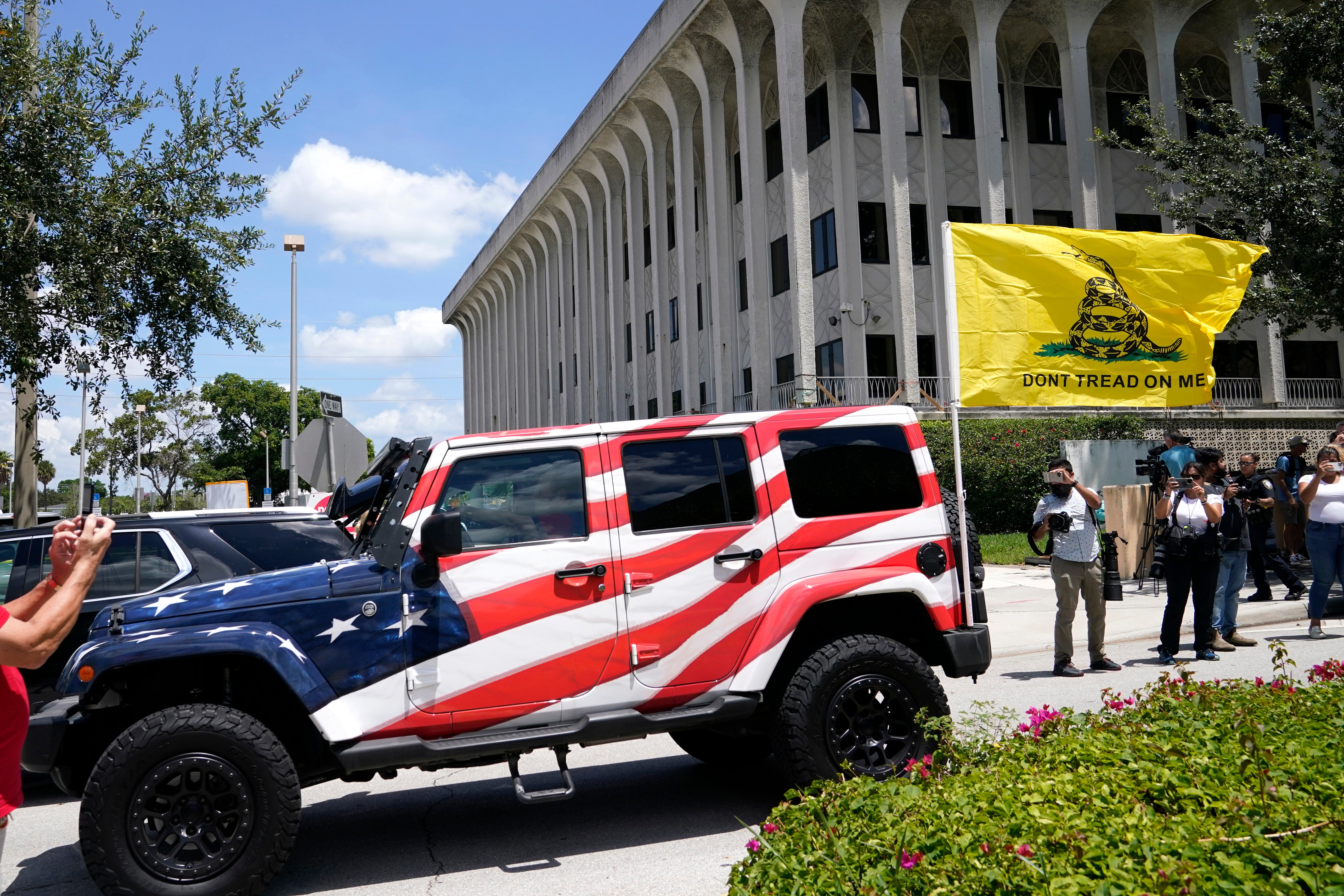 A vehicle painted with the American flag drives past the Paul G. Rogers Federal Courthouse, Thursday, Aug. 18, 2022, in West Palm Beach, Fla