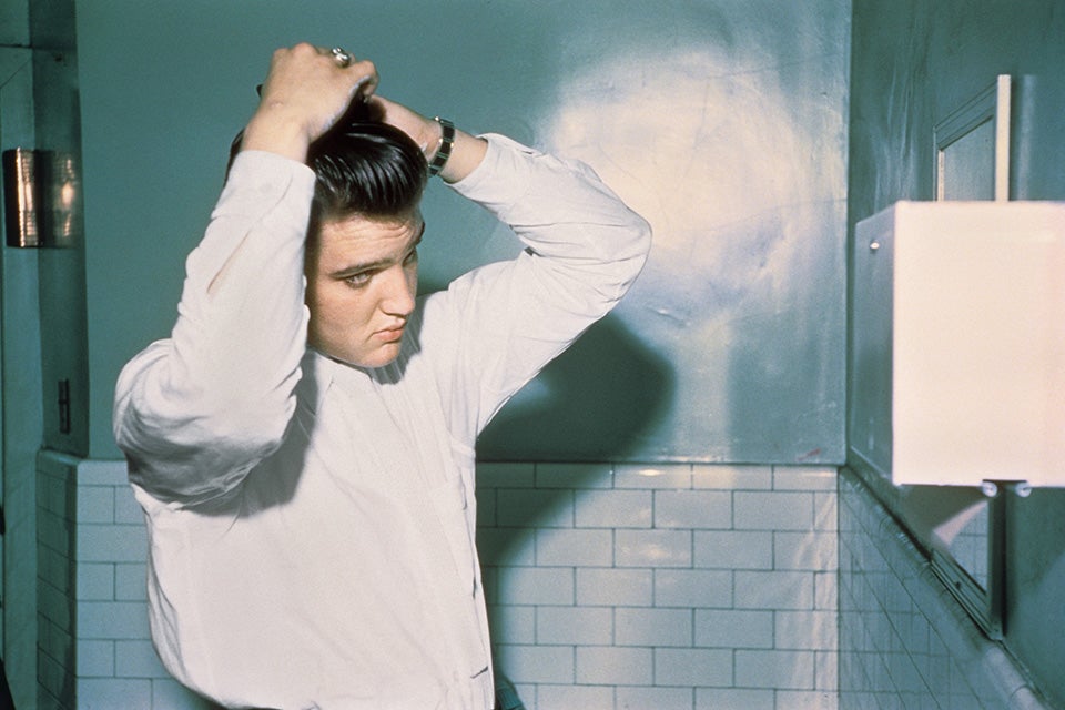 Elvis tending to his pompadour in the men’s room of the Mosque Theater, Richmond, Virginia, 30 June 1956