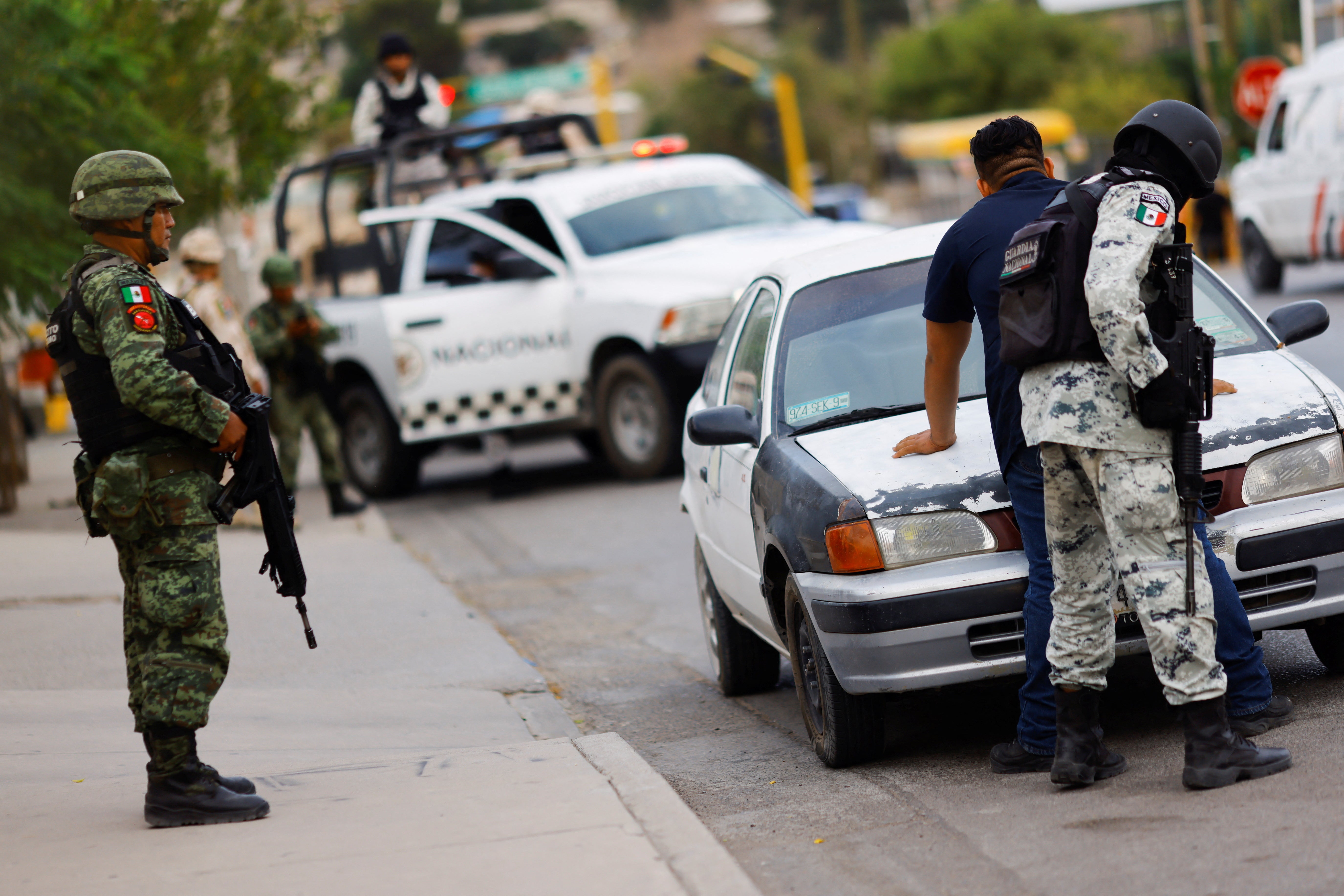 Members of the Mexican Army and National Guard check a car at a military checkpoint, as part of a security operation to reduce violence, in Ciudad Juarez, Mexico, on 16 August 2022