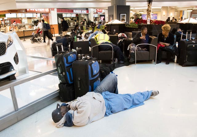 <p>Un hombre duerme en el suelo en el aeropuerto de Atlanta</p>
