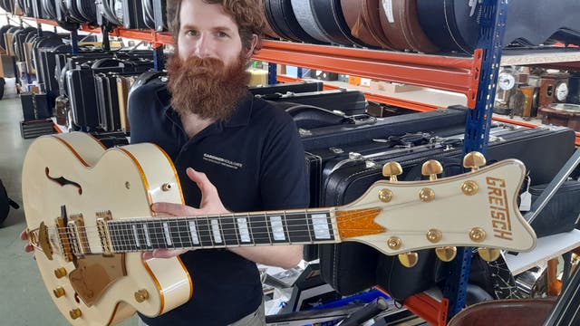 Auctioneer Luke Hobbs with the guitar Dave Grohl played on the Foo Fighters’ first hit videos (Gardiner Houlgate/PA)