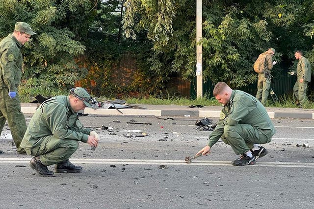 <p>Investigators work on the site of an explosion that wrecked a car driven by Darya Dugina outside Moscow</p>